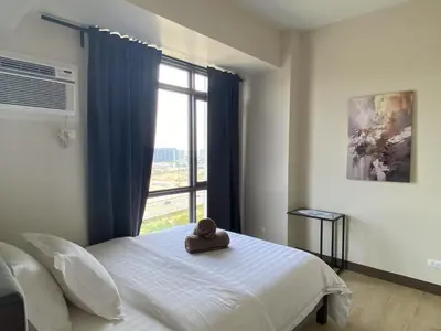 a bedroom with a bed with a large window at 1BR 2 mins to Okada near MOA & Airport-12C in Manila