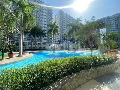 a swimming pool with palm trees and water fountains at Great Price and Location in Moa, Pasay City, Philippines in Manila