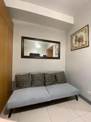 a couch in a living room with a mirror at Great Price and Location in Moa, Pasay City, Philippines in Manila
