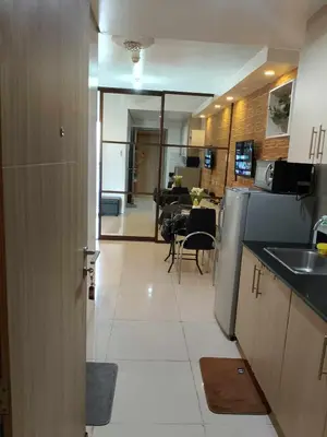 a kitchen with a sink and a refrigerator at Affordable unit near MOA walking distance to picc in Manila