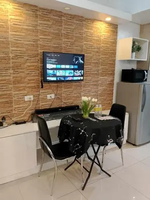 a dining room with a table and chairs and a tv at Affordable unit near MOA walking distance to picc in Manila