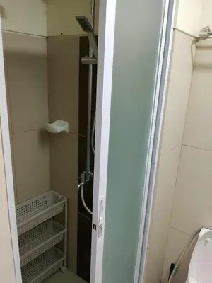 a small bathroom with a shower and a sink at Affordable unit near MOA walking distance to picc in Manila