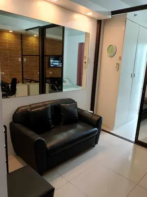 a black leather couch in a room with a mirror at Affordable unit near MOA walking distance to picc in Manila