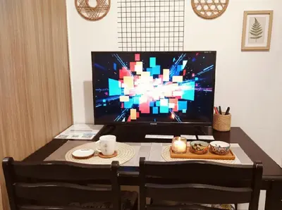 a dining room table with a television and a table with chairs at Mall of Asia - Aseana Residences SHORE APARTMENTS in Manila