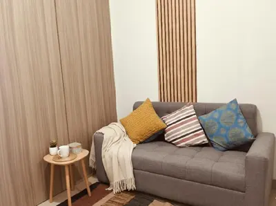 a living room with a couch with pillows and a table at Mall of Asia - Aseana Residences SHORE APARTMENTS in Manila