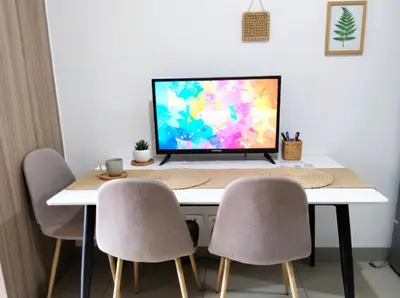 a computer monitor sitting on top of a table with chairs at Mall of Asia - Aseana Residences SHORE APARTMENTS in Manila