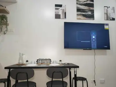 a table with chairs and a tv on a wall at ARCHIVED 2019 - Cavite Condo with Resort-like Amenities & Hi Speed Wifi in Dasmariñas