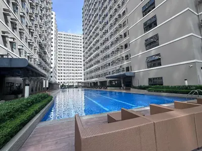a swimming pool in the middle of two tall buildings at ARCHIVED 2019 - Cavite Condo with Resort-like Amenities & Hi Speed Wifi in Dasmariñas