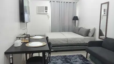 a small living room with a bed and a table at 2019 Cavite Green 2 Condo Amenities HI Speed Wifi in Dasmariñas