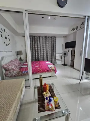 a living room with a bed and a table with food at The Bahamas & Maldives Suites by Azure Urban Resort Residences in Manila