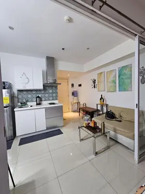a kitchen and a living room with a couch at The Bahamas & Maldives Suites by Azure Urban Resort Residences in Manila