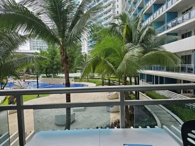 a view from the balcony of a resort with palm trees at The Bahamas & Maldives Suites by Azure Urban Resort Residences in Manila