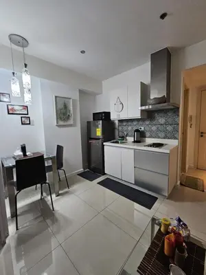 a kitchen and dining room with a table and a counter top at The Bahamas & Maldives Suites by Azure Urban Resort Residences in Manila