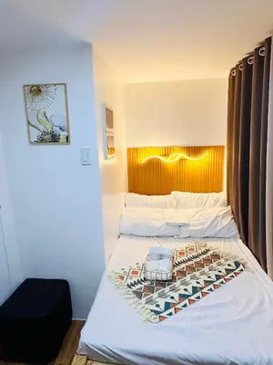 a bedroom with two beds with a headboard and a bed sidx sidx at 2 Bedroom and Bathroom Staycation Condo in Mandaluyong City near BONI MRT with WIFI and KARAOKE and POOL in Manila