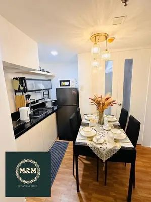 a kitchen with a table with chairs and a dining room at 2 Bedroom and Bathroom Staycation Condo in Mandaluyong City near BONI MRT with WIFI and KARAOKE and POOL in Manila