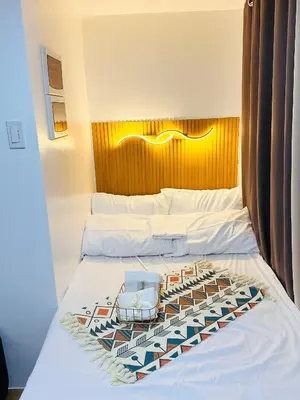 a hotel room with two beds and a headboard at 2 Bedroom and Bathroom Staycation Condo in Mandaluyong City near BONI MRT with WIFI and KARAOKE and POOL in Manila