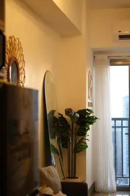 a room with a potted plant and a window at Cozy and Stylish Unit in Fame Residences in Manila