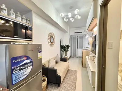 a small living room with a couch and a kitchen at Cozy and Stylish Unit in Fame Residences in Manila