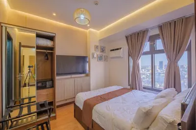 a hotel room with a bed and a large window at 1Br Suite w Balcony in Pasay - The Radiance Manila Bay in Manila