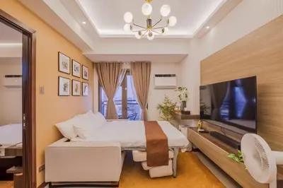 a bedroom with a large bed and a television at 1Br Suite w Balcony in Pasay - The Radiance Manila Bay in Manila