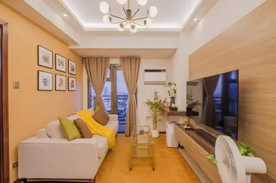 a living room with a white couch and a tv at 1Br Suite w Balcony in Pasay - The Radiance Manila Bay in Manila