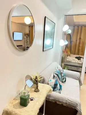 a living room with a table and a mirror at Yana's Place - Azure Residences in Manila