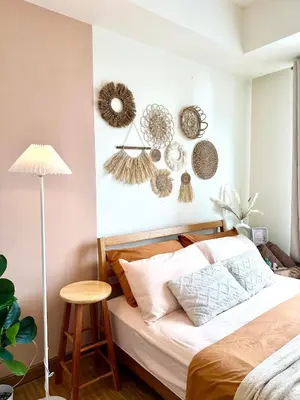 a bedroom with a bed and some decorations on the wall at Cozy Stays - Azure in Manila
