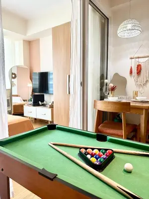 a living room with a pool table in a room at Cozy Stays - Azure in Manila