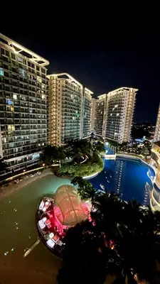a view of a city at night with tall buildings at Cozy Stays - Azure in Manila
