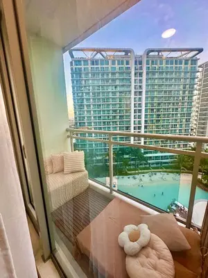 a balcony with a view of a large building at Cozy Stays - Azure in Manila