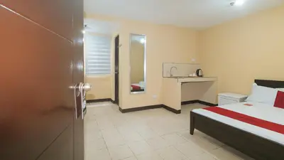 a bedroom with a bed and a desk in it at RedDoorz at MUBG Apartelle near Baclaran Church in Manila