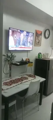 a room with a table and a tv on the wall at CHIC ROOM pasay sea residence in Manila