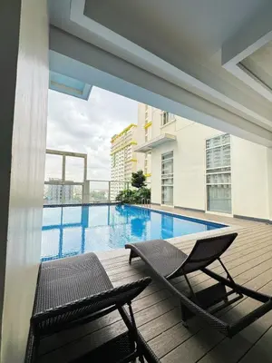 a deck with a chair and a swimming pool at Sleek & Chic One-Bedroom in Manila