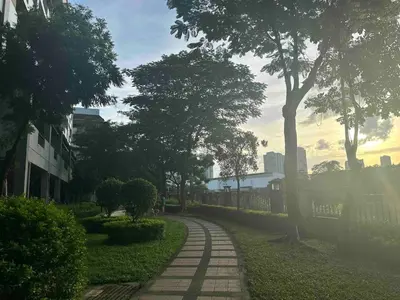 a walkway in a park with trees and a building at Modern Japanese Resort-Type Condo in Manila