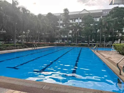 a large swimming pool with blue water in front of a building at Modern Japanese Resort-Type Condo in Manila