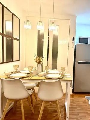 a dining room with a table with chairs and a refrigerator at EDSA Cozy 3BR near MRT w Netflix and Karaoke Fun in Manila