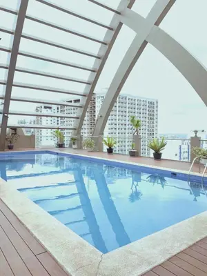 a swimming pool on the roof of a building at Cozy 2 BR 2 Bath Condo with Netflix and Karaoke near MRT EDSA in Manila