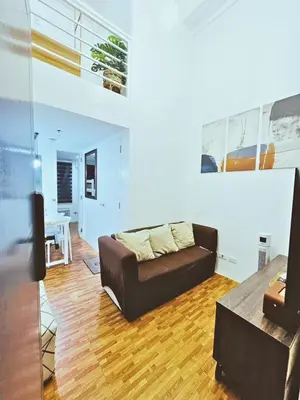 a living room with a couch and a table at Cozy 2 BR 2 Bath Condo with Netflix and Karaoke near MRT EDSA in Manila