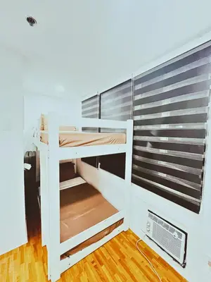 a white bunk bed in a room with a window at Cozy 2 BR 2 Bath Condo with Netflix and Karaoke near MRT EDSA in Manila