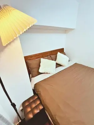 a bedroom with a bed with two pillows on it at Cozy 2 BR 2 Bath Condo with Netflix and Karaoke near MRT EDSA in Manila