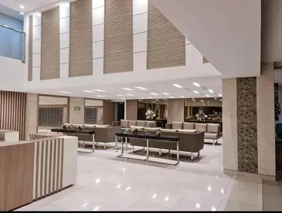 a lobby with couches and tables in a building at Field Residences Hotel Apartments Near Manila Airport in Manila