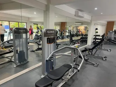 a gym with cardio equipment and people in the background at Field Residences Hotel Apartments Near Manila Airport in Manila