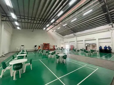 a tennis court with tables and chairs in a room at Field Residences Hotel Apartments Near Manila Airport in Manila