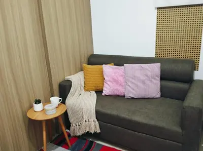 a living room with a couch with colorful pillows at Mall of Asia - Pasay Condo in Manila