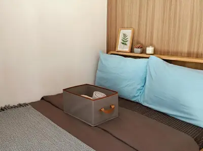 a bed with a blue pillow and a box on it at Mall of Asia Accommodation in Manila