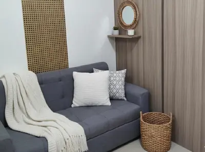 a blue couch sitting in a room with a mirror at Mall of Asia Accommodation in Manila