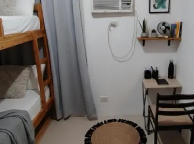 a bedroom with a bunk bed and a desk with a fan at MOA - Aseana Pasay Condo in Manila