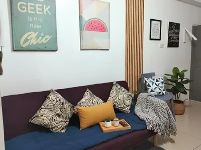 a blue couch with pillows on it in a living room at MOA Apartment in Pasay in Manila