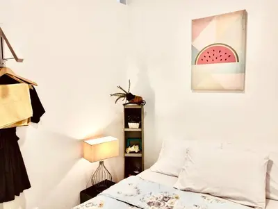 a bedroom with a bed and a painting of a watermelon at Ortigas Greenfield Cozy Lodge in Manila