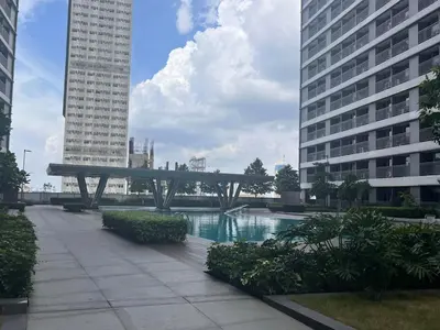 a bridge in the middle of a city with buildings at Ortigas Greenfield Cozy Lodge in Manila